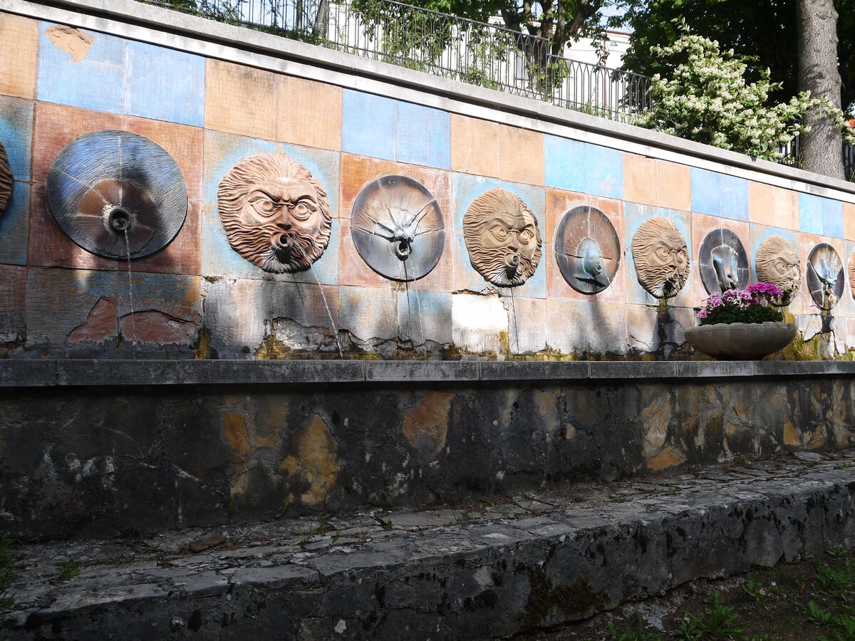The Fountain of the Masks in Canistro, water pouring from carved stone faces