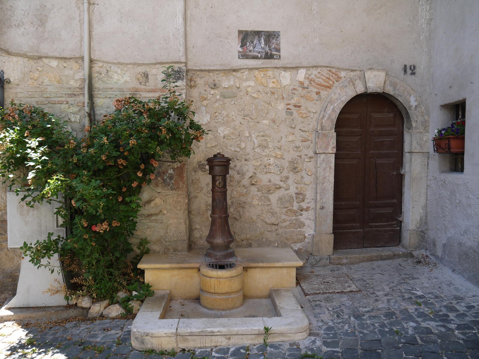 An old stone fountain in a quiet corner of the village