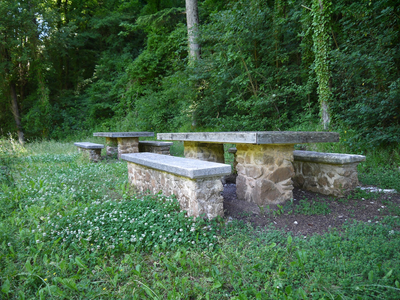 Stone picnic tables near the entrance to the cave reserve