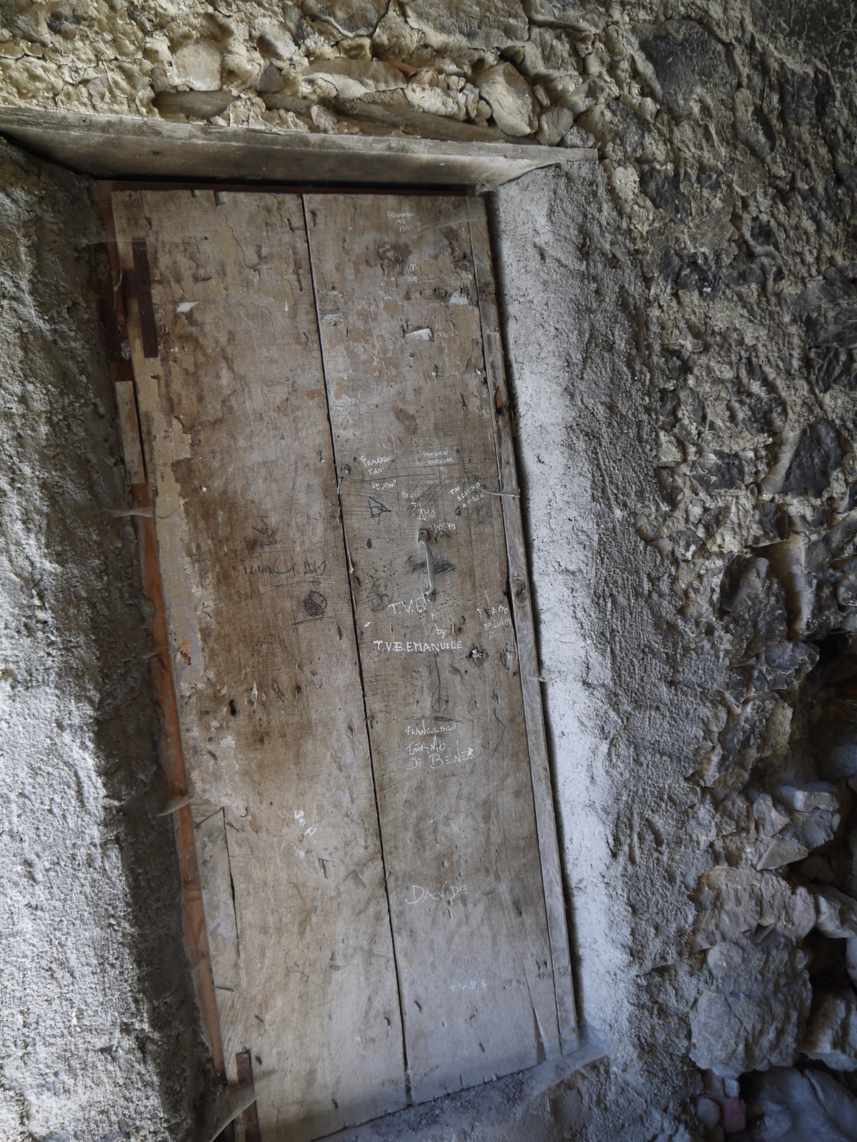 An old wooden door set into an arched stone doorway