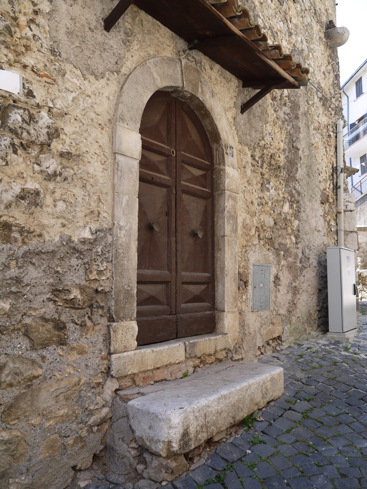 A wooden door under an arched stone entrance