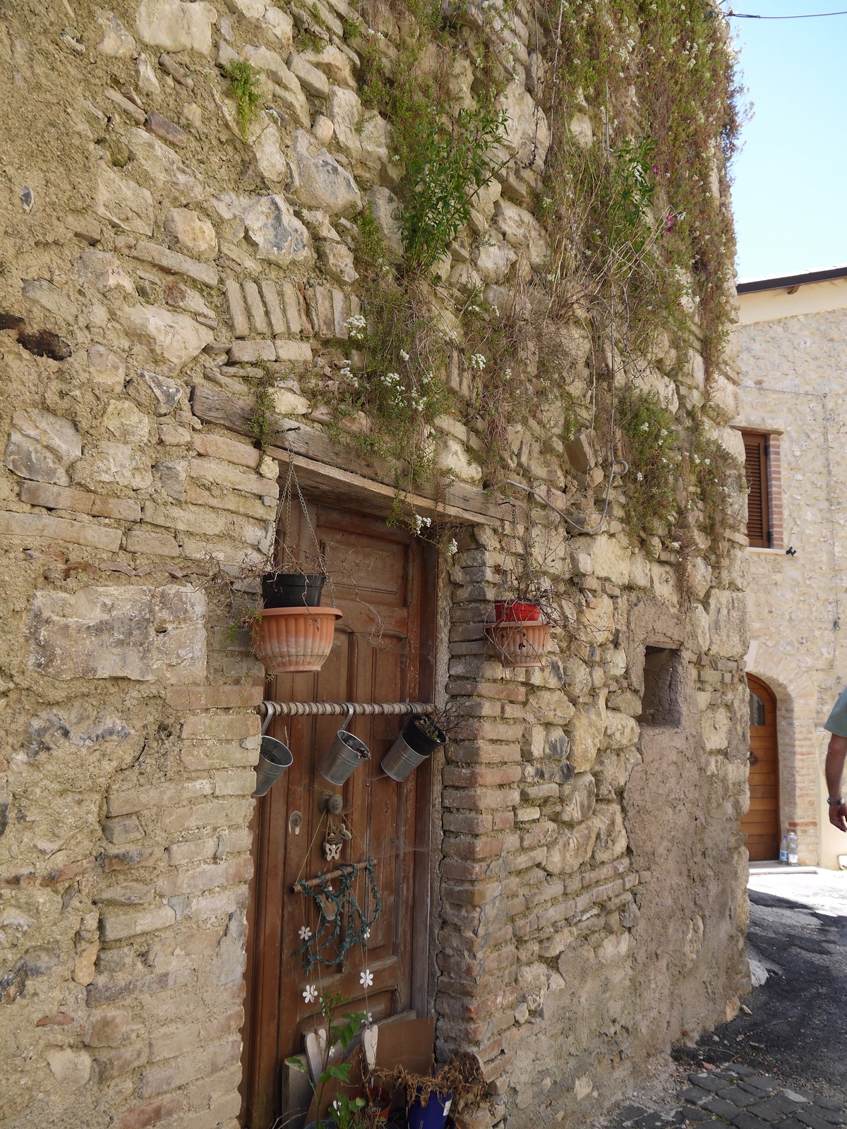 A stone door decorated with hanging flower pots