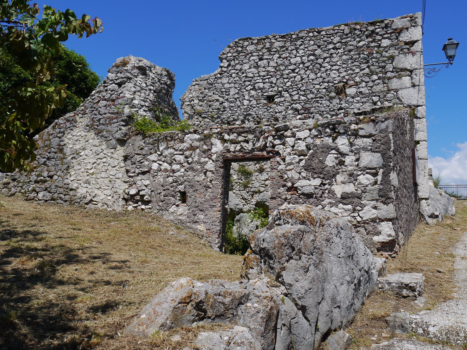 A gap in the ruined stone walls looking out toward the surrounding mountains